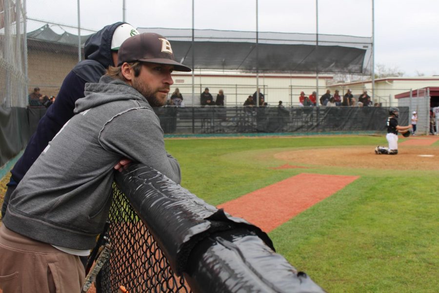 Madsen leans against the fence at Rancho Buena Vista High School observing the Sage Creek JV team at a preseason game. Sage Creek played several teams in “Winter Ball” to prepare for the regular season of Divison 1 baseball.