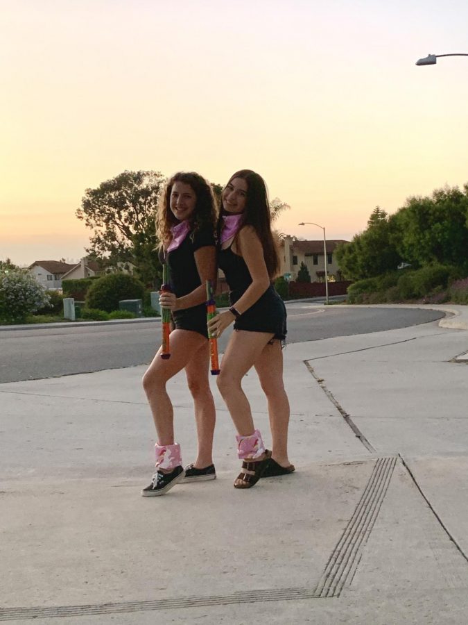 Morgan Mayorga and Maya Grudman stand in their floaties and matching outfits holding their “weapons” of choice. The pair are two of the game coordinators who organize the event. 