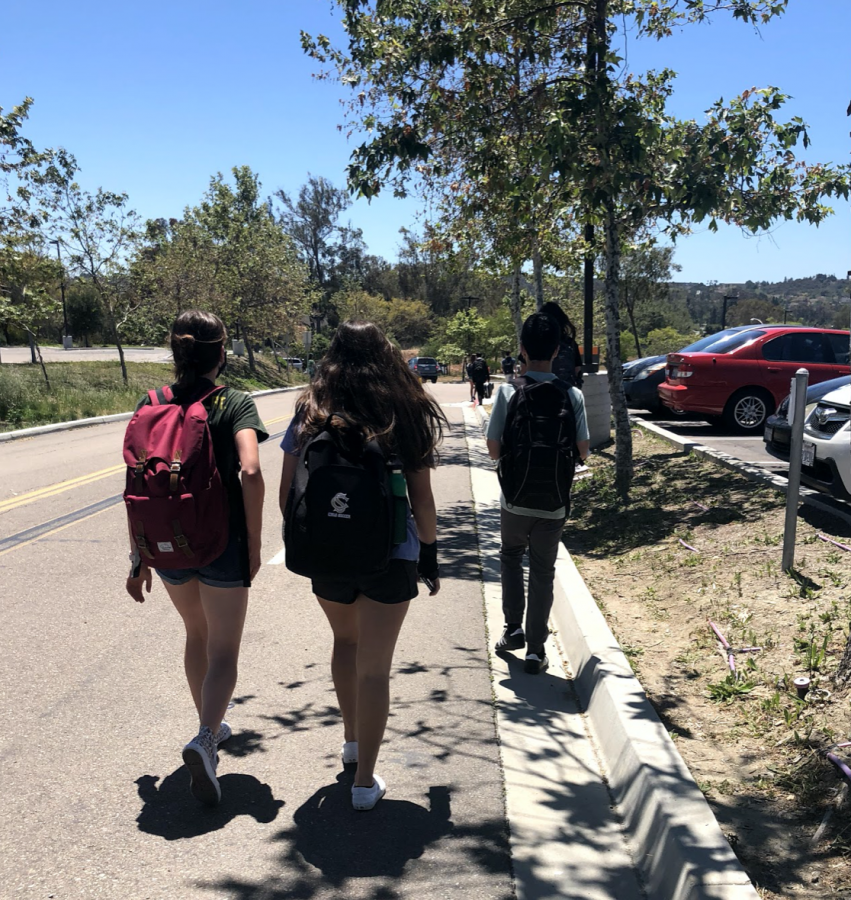 A group of students walks home after a short day of school. Each day, students are released from school at 12:35.