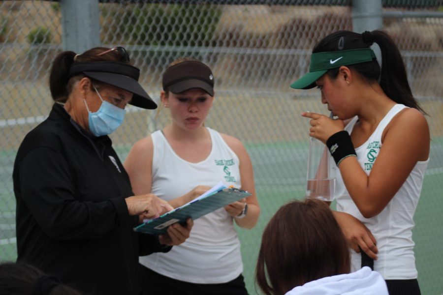 Jordan explains strategies and switches players. She has coached tennis for over 20 years.