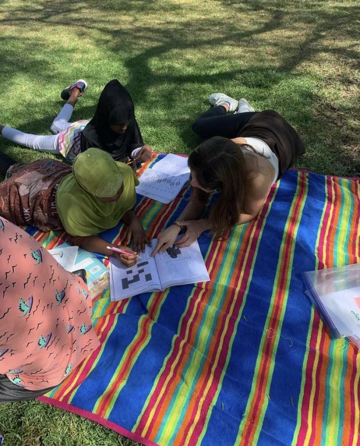 Club President, Sofia Miracco, tutors fifth graders Aisha (10) and Najah (10). She teaches them complex addition problems and long division. 