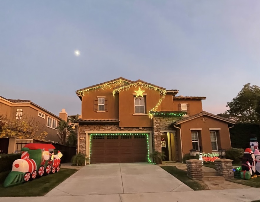 The lights of one house on Ammonite Court begin to illuminate as the sun sets. This house is one of the easier ones to take lights off once the holiday season ends.