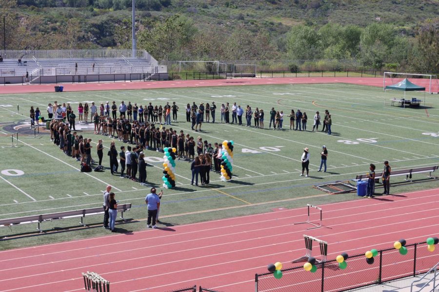 Track and field teammates and parents celebrate the team's graduating seniors on the field. Celebrations began in advance of the team's final home meet. 