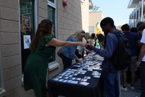 Genius Project coordinator Shannon Alberts passes out name tag lanyards to presenting juniors. Alberts led the busy day on Thursday.