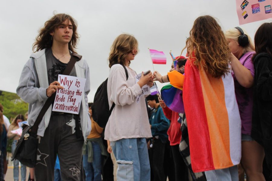 A walks through the crowd with a poster. An estimated one to two hundred students attended the walkout.