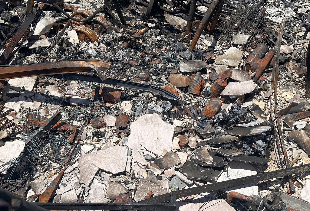 Lahaina was burnt to the ground. The wreckage from the buildings piles on the concrete.