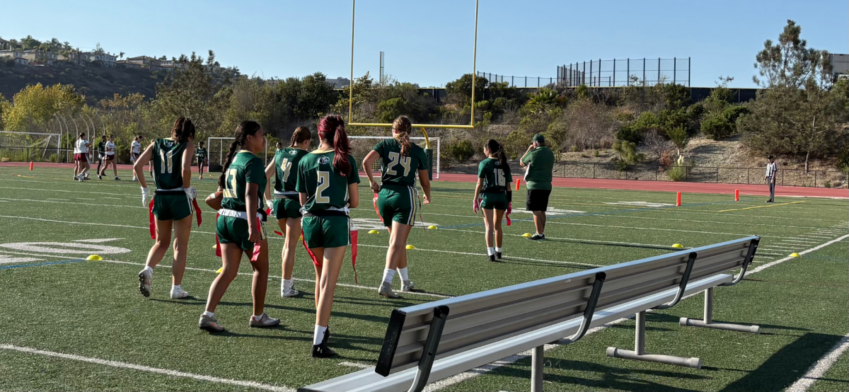 The offensive line makes their way down the sidelines to cheer on their defense. The girls watch their defense stop Mission Hills from scoring.