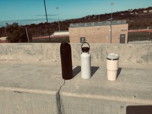 The three biggest trending water bottle brands, Owala, Hydro Flask and Stanley, sit side by side in the sun at Sage Creek High School.