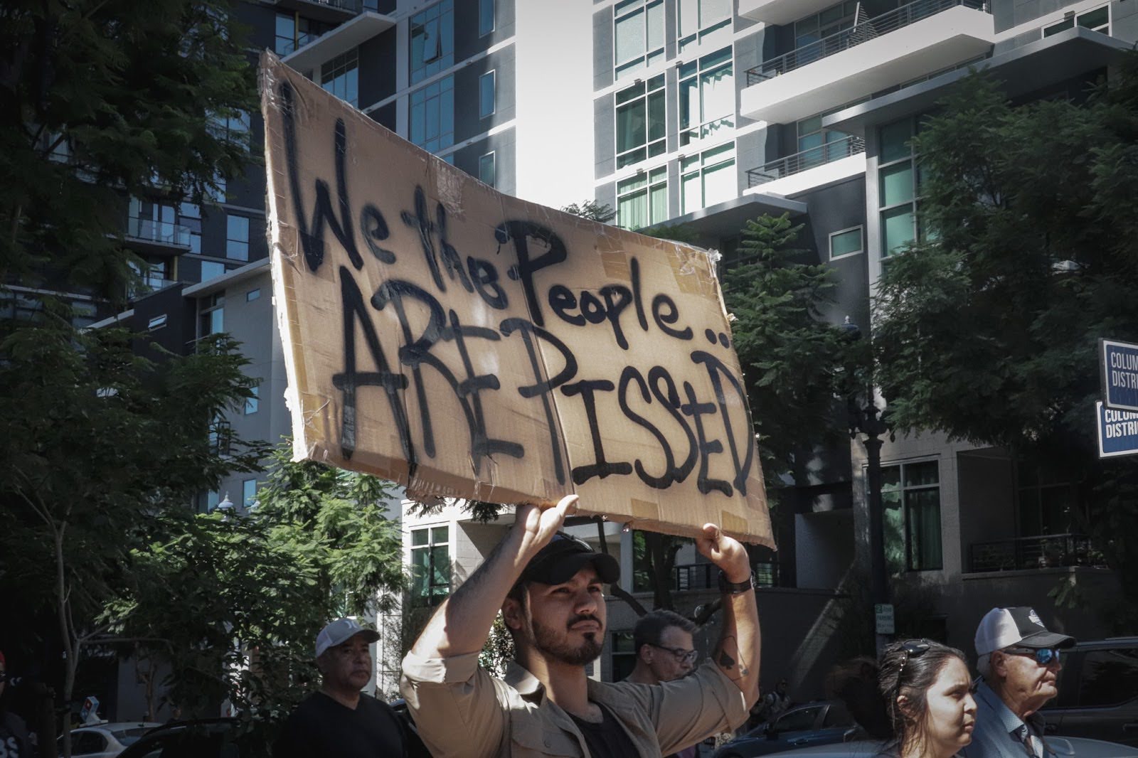 A protester holds a sign as he marches through the streets. He and along with a massive crowd, began to march to spread away from the marina.
