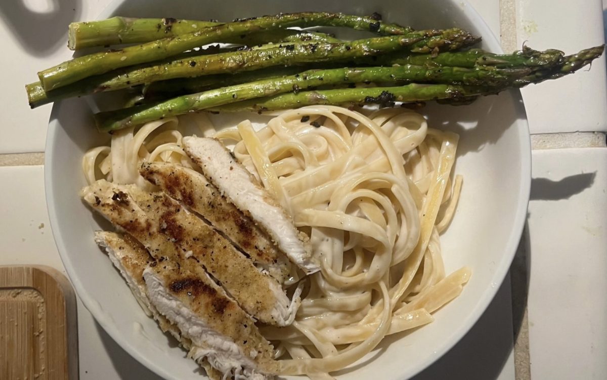 After an hour of careful cooking, dinner is finally served. Garlic herb chicken accompanied with fettuccine alfredo and seasoned asparagus, a household favorite.